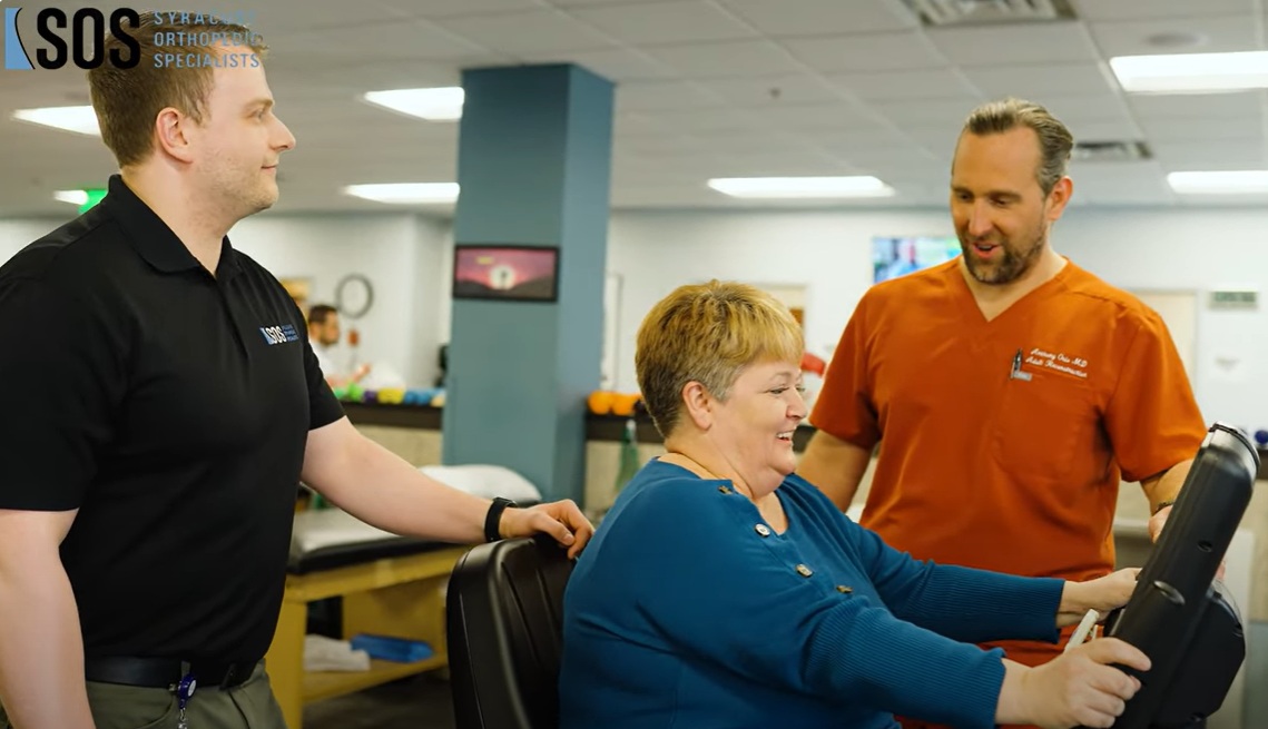 physical therapy near syracuse ny patient exercising and smiling with physical therapists