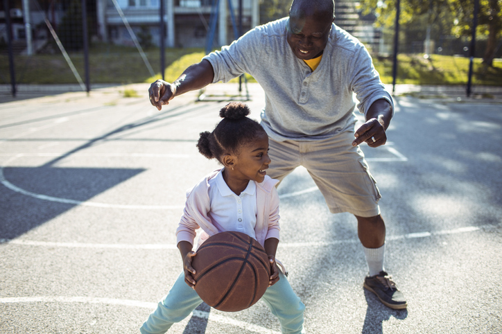 Active grandfather plays basketball with granddaughter after hip replacement