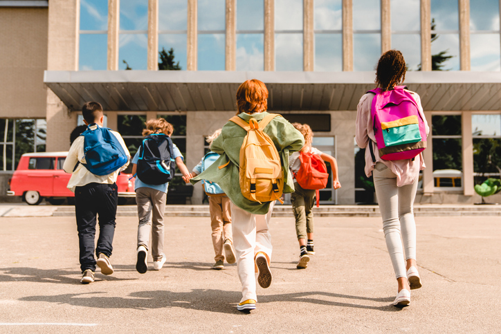 Students walking into school with backpacks