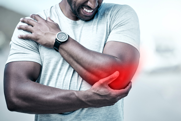 Man holding injured elbow in pain